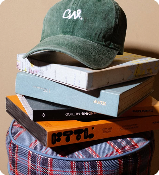CreativeWise cap on stack of books