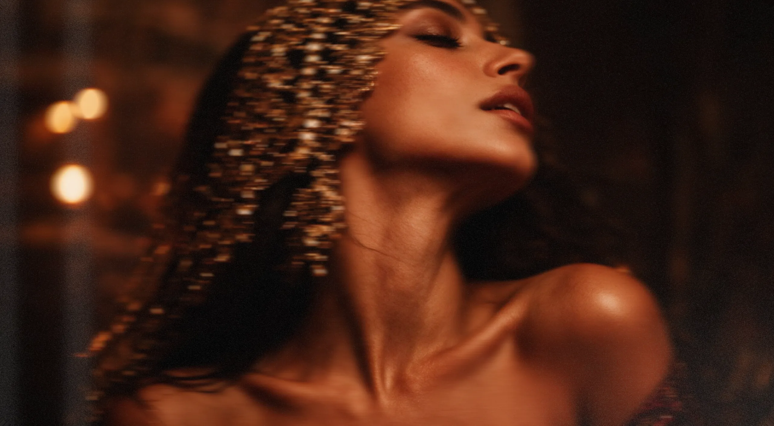 Celion — editorial portrait, a model with golden beaded hair in warm candlelight
