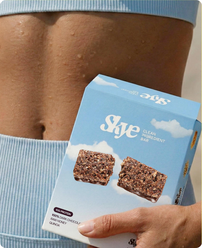 Skye — a hand holding a box of Skye bars against sky-blue striped activewear in a lifestyle shot