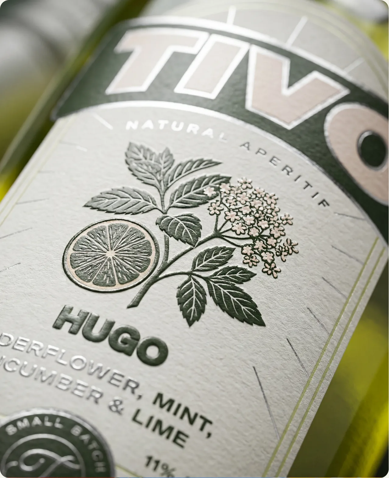 Tivo: an extreme close-up of the Hugo label, cream stock with an engraved botanical of citrus and elderflower, reading elderflower, mint, cucumber and lime