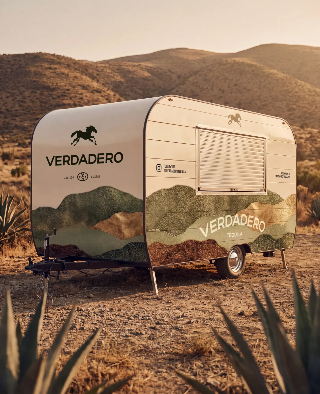Verdadero — a branded travel trailer parked among the agave in the desert