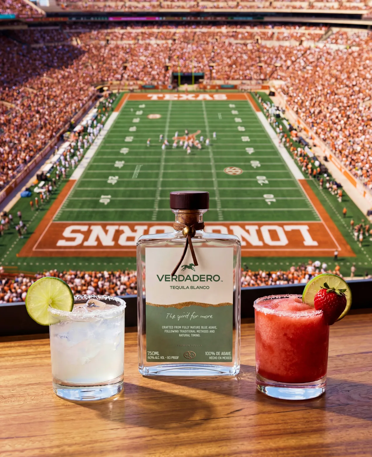 Verdadero — Tequila Blanco bottle on a bar rail between a classic and a strawberry margarita, the Longhorns stadium field behind